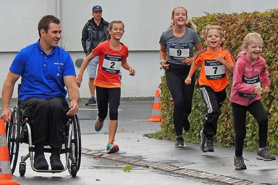 Vier Kinder und ein Mann im Rollstuhl nehmen an einem Spendenlauf in Oberurnen teil.