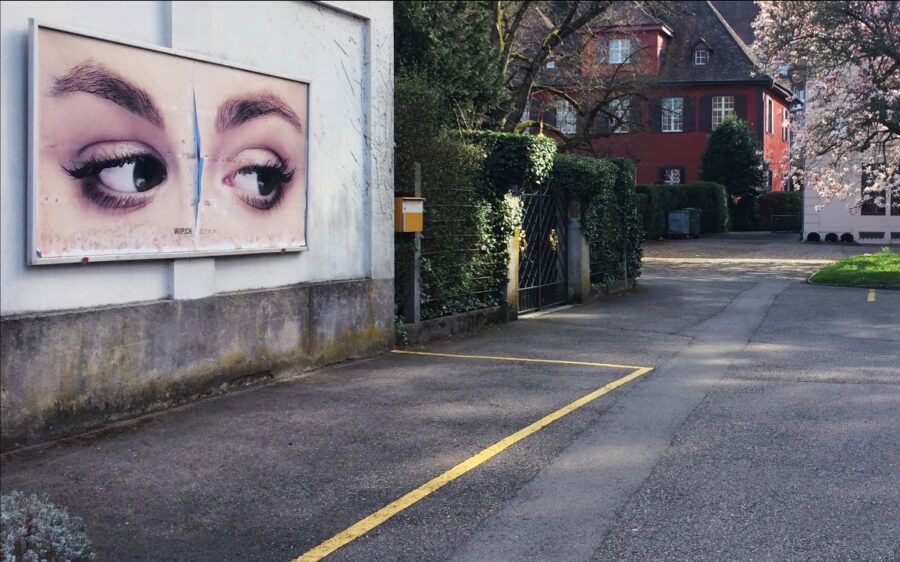 Auf dem Bild ist ein Plakat mit zwei grossen Augen zu sehen. Das Plakat ist an einer Wand befestigt.