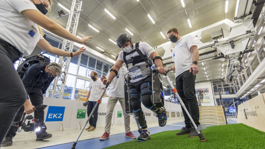 Mann mit Querschnittlähmung läuft im Exoskelett, Roboteranzug, durch CYBATHLON Parcours.
