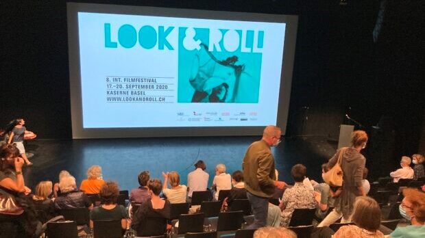 Eine Vorführung im Kino von Look&Roll. Menschen sitzen im Publikum und schauen auf eine Leinwand.
