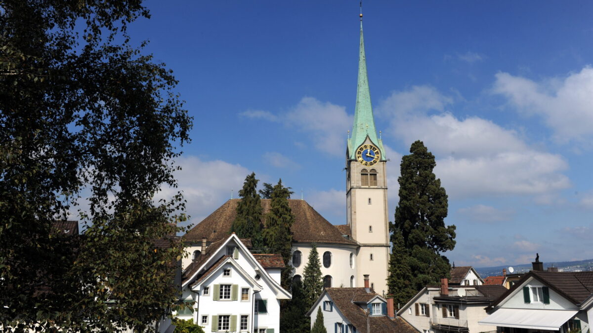 Veranstaltungsort Reformierte Kirche Horgen, Aussenansicht über die Hausdächer im Dorfkern mit dem imposanten Kirchturm in der Bildmitte.