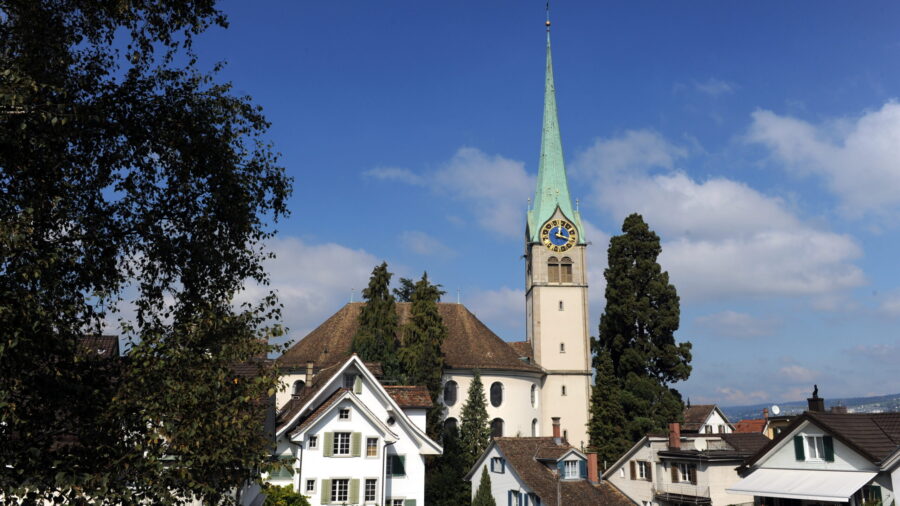 Veranstaltungsort Reformierte Kirche Horgen, Aussenansicht über die Hausdächer im Dorfkern mit dem imposanten Kirchturm in der Bildmitte.