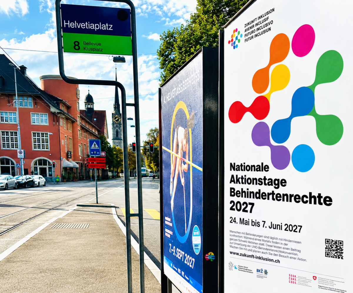 Werbeplakat an einer Tramhaltestelle am Helvetiaplatz in Zürich. Das Plakat wirbt für die Nationalen Aktionstage Behindertenrechte 2027 vom 24. Mai bis 7. Juni 2027. Es zeigt das farbige Logo von «Zukunft Inklusion», farbige ineinandergreifende Formen, Informationen zu den Aktionstagen, einen QR-Code und die Logos der beteiligten Organisationen. Im Hintergrund sind Tramgleise, Häuser und ein Kirchturm zu sehen.
